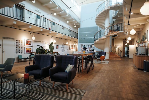 A spacious, multi-level interior with a central staircase, modern furniture, and artwork on the walls.