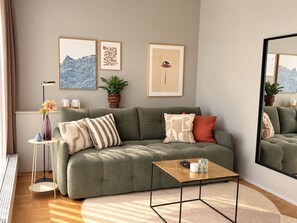 Een moderne woonkamer met een groene bank, een salontafel en een grote spiegel.
