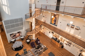 A multi-level hotel lobby with a central spiral staircase, seating areas, and a reception desk. - Second Home Hotel & Apartments (Solna)