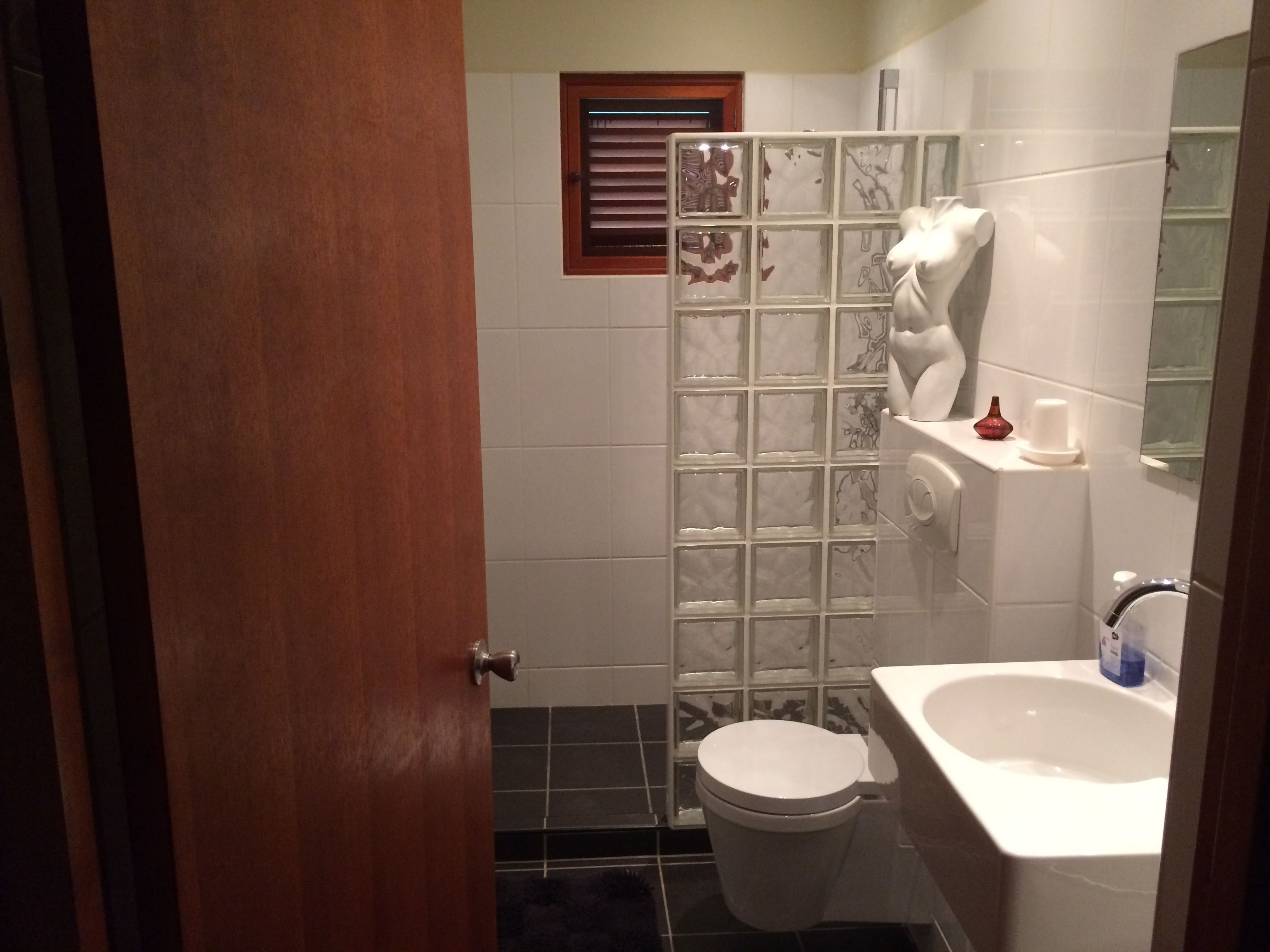 A bathroom with a toilet, a shower enclosure, a bathtub, and a mirror.