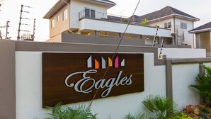 A sign with the word "Eagles" and a logo with colorful arrows. - Eagle's (Accra)