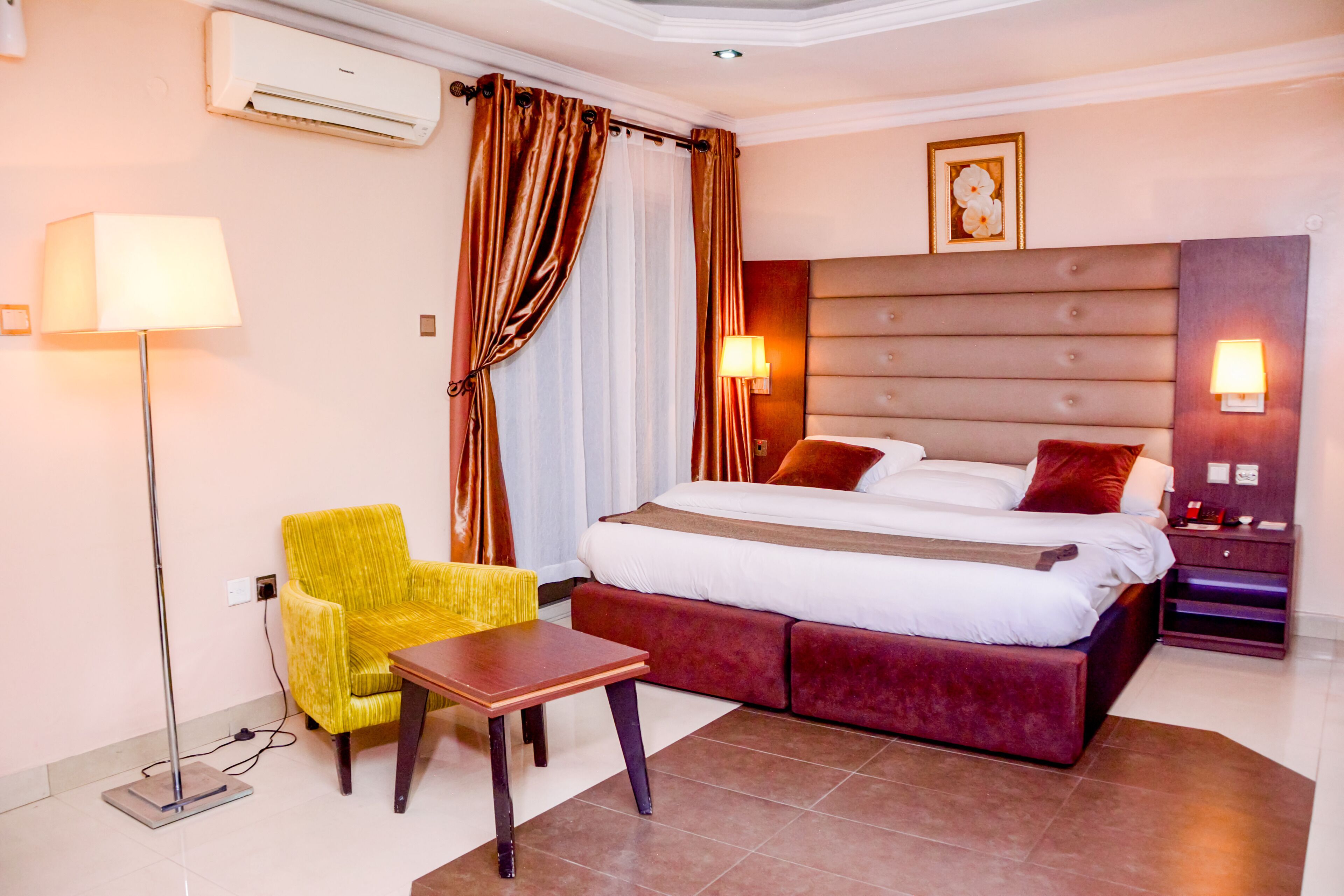 Ein Hotelzimmer mit Bett, Stuhl, Tisch und Lampe.