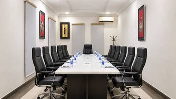 A conference room with a long table, black chairs, and water bottles.