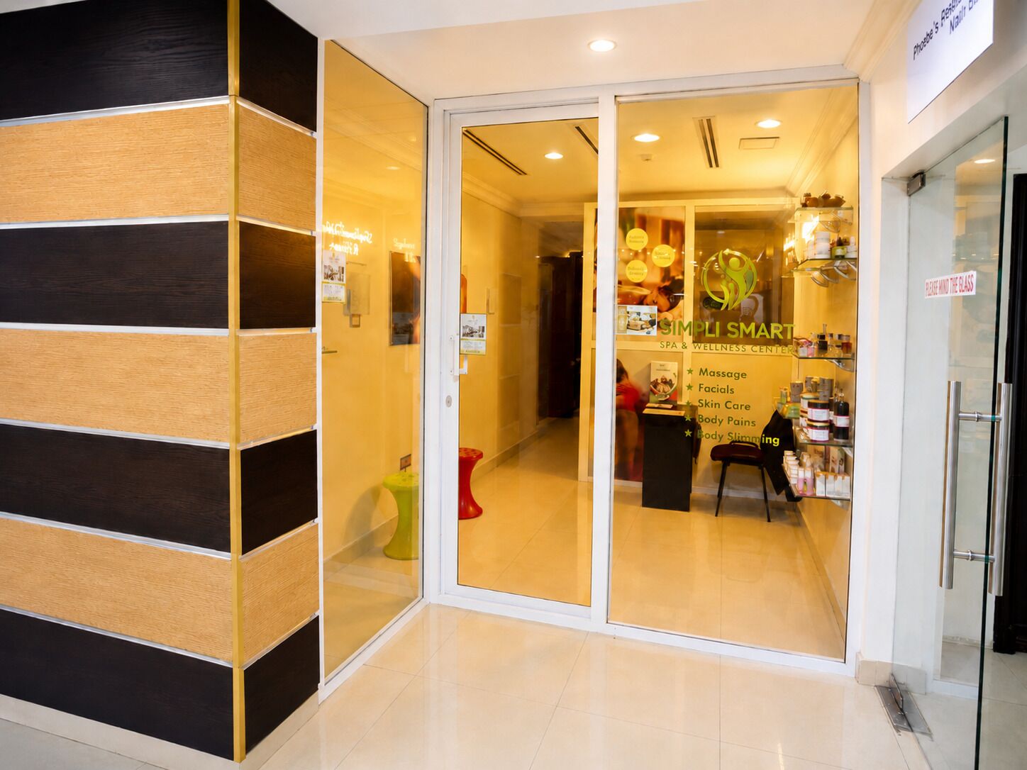 A spa and wellness center with a glass entrance and a sign listing services like massage, facials, and body care.