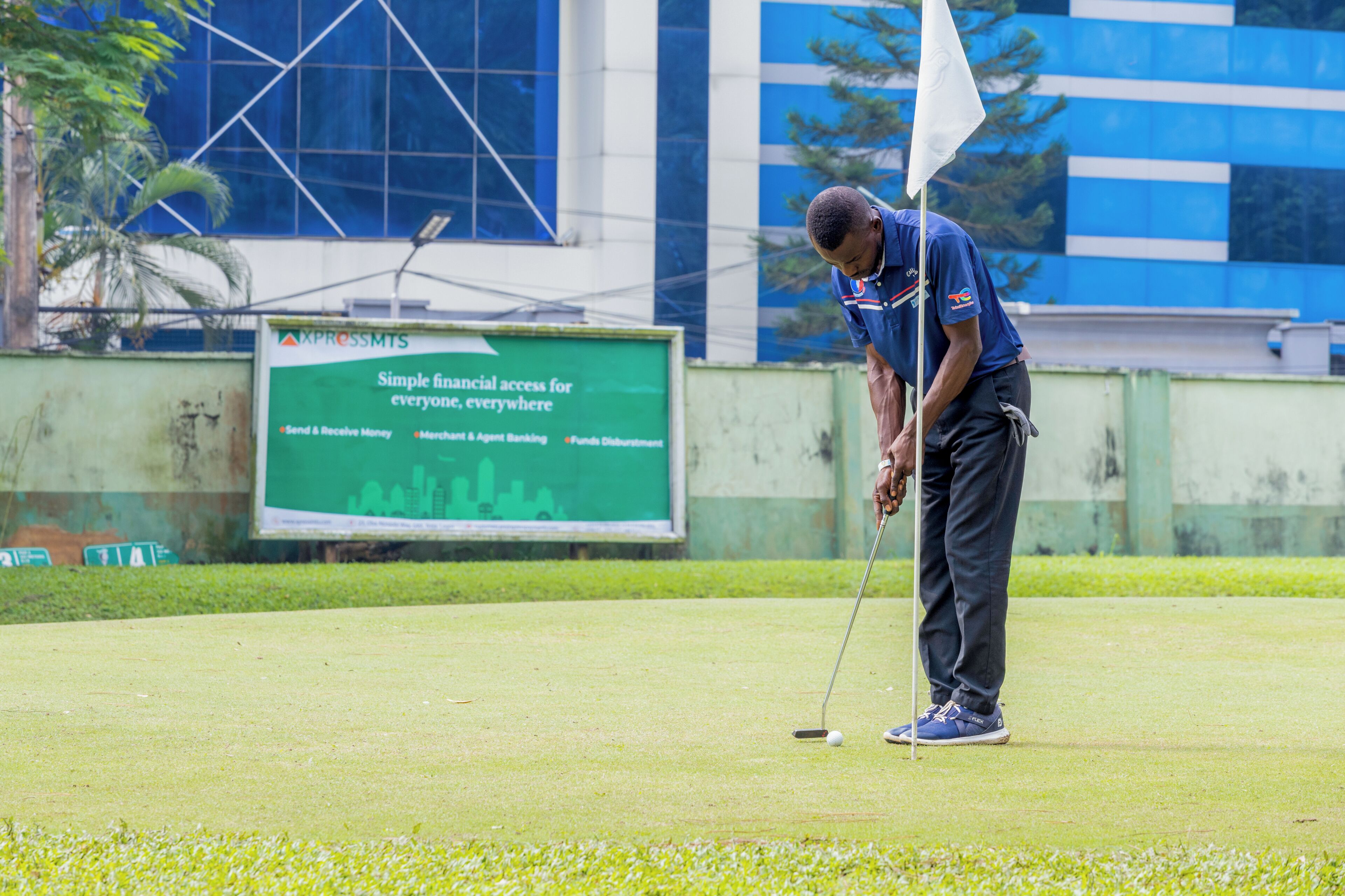 A golf course with a signboard in the background.