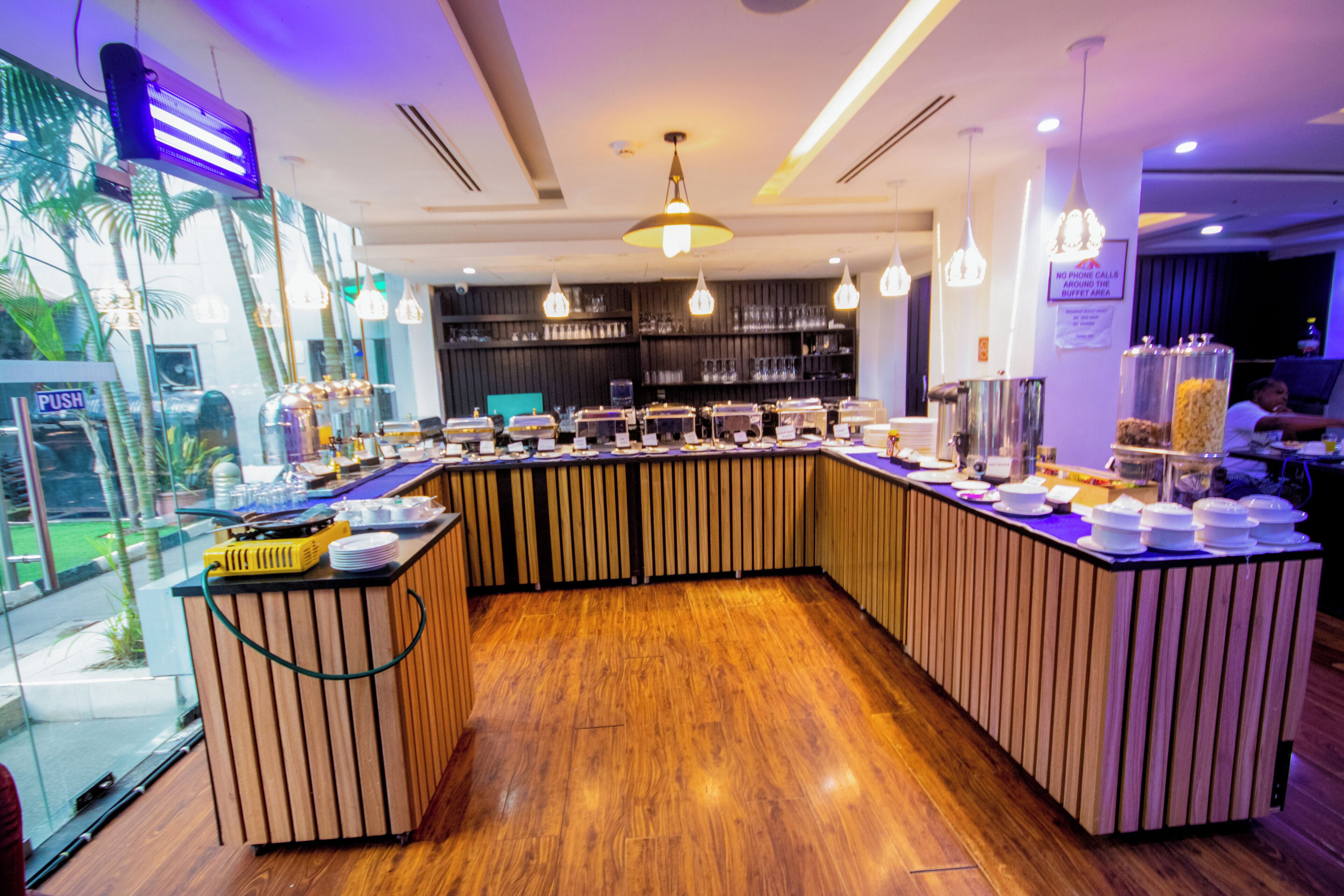 A buffet area with a curved counter, multiple serving stations, and a variety of food containers.