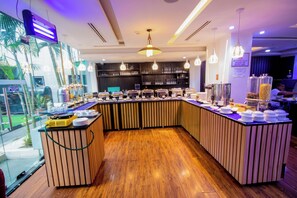 A buffet area with a curved counter, multiple serving stations, and a variety of food containers. - GolfView Suites & Conference Center (Lagos)