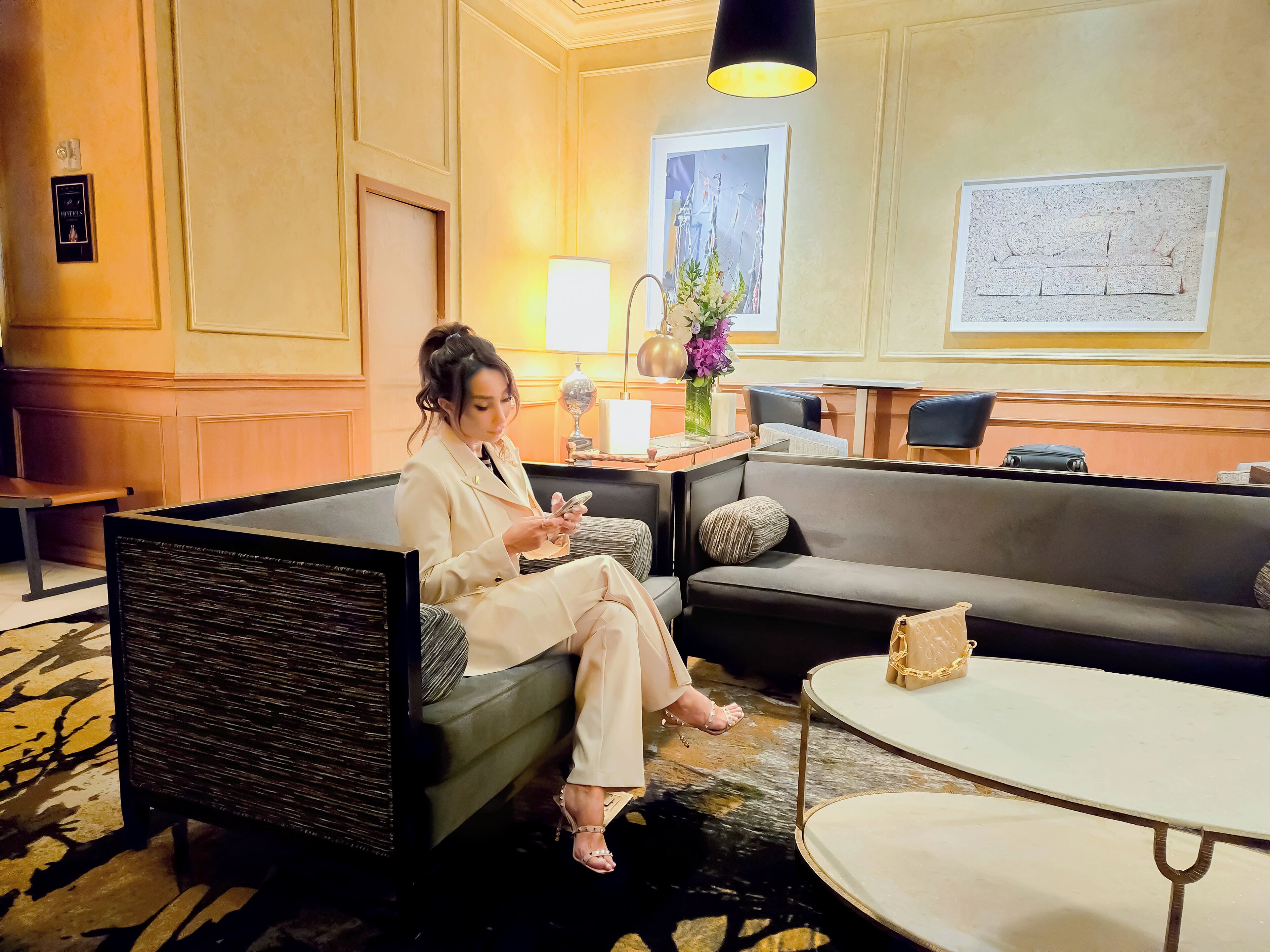 A hotel lobby with a seating area, a reception desk, and a large window.