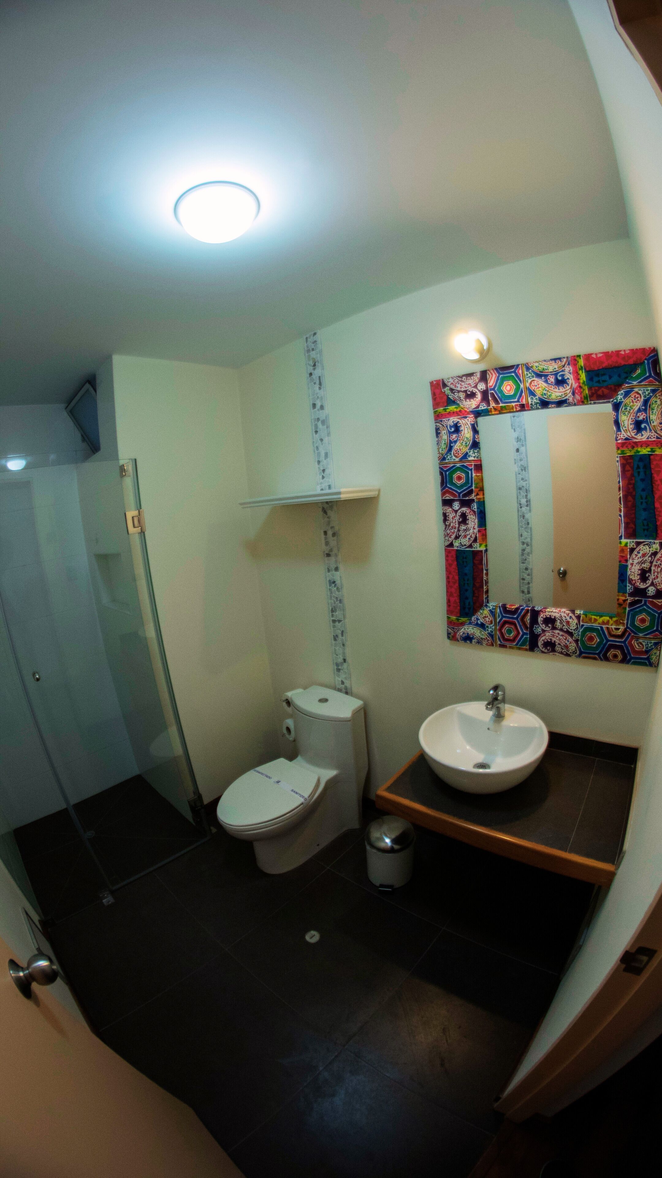 Une salle de bain équipée de toilettes, d’un lavabo et d’une douche.