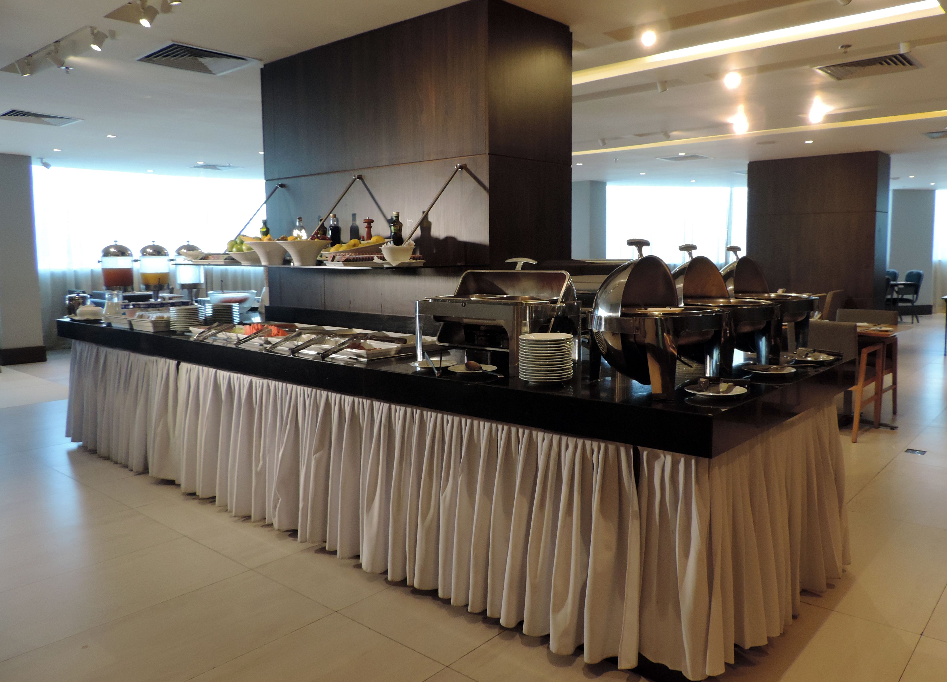 Un buffet avec différents postes de service proposant divers plats et une machine à café.