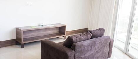 A modern living room with a dark brown sofa and a wooden side table.