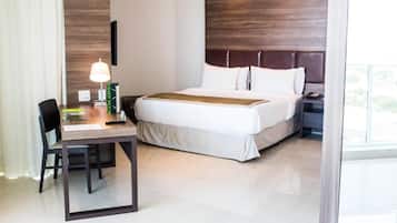 Een hotelkamer met een bed, een bureau met een lamp en een stoel.