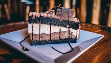 A slice of layered cake with chocolate and white frosting on a white plate.