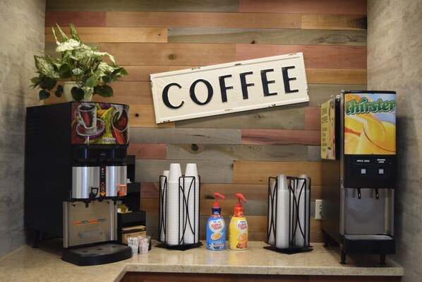 Una estación de café con un cartel que dice "COFFEE" y una máquina de café Thirsty.