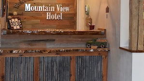 A reception desk at Mountain View Hotel with a wooden design, a welcome sign, and a calendar displaying March 3. - Mountain View Hotel (Killdeer)