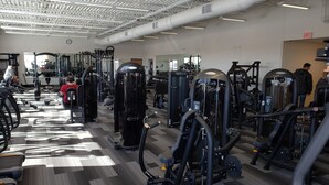 A gym with various exercise machines, treadmills, and a mirrored wall. - Mountain View Hotel (Killdeer)