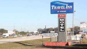 En skylt för motellkedjan Travel Inn i Sebring, med en skylt som visar att det finns lediga rum och en skylt som visar att det finns parkeringsplats för lastbilar.
