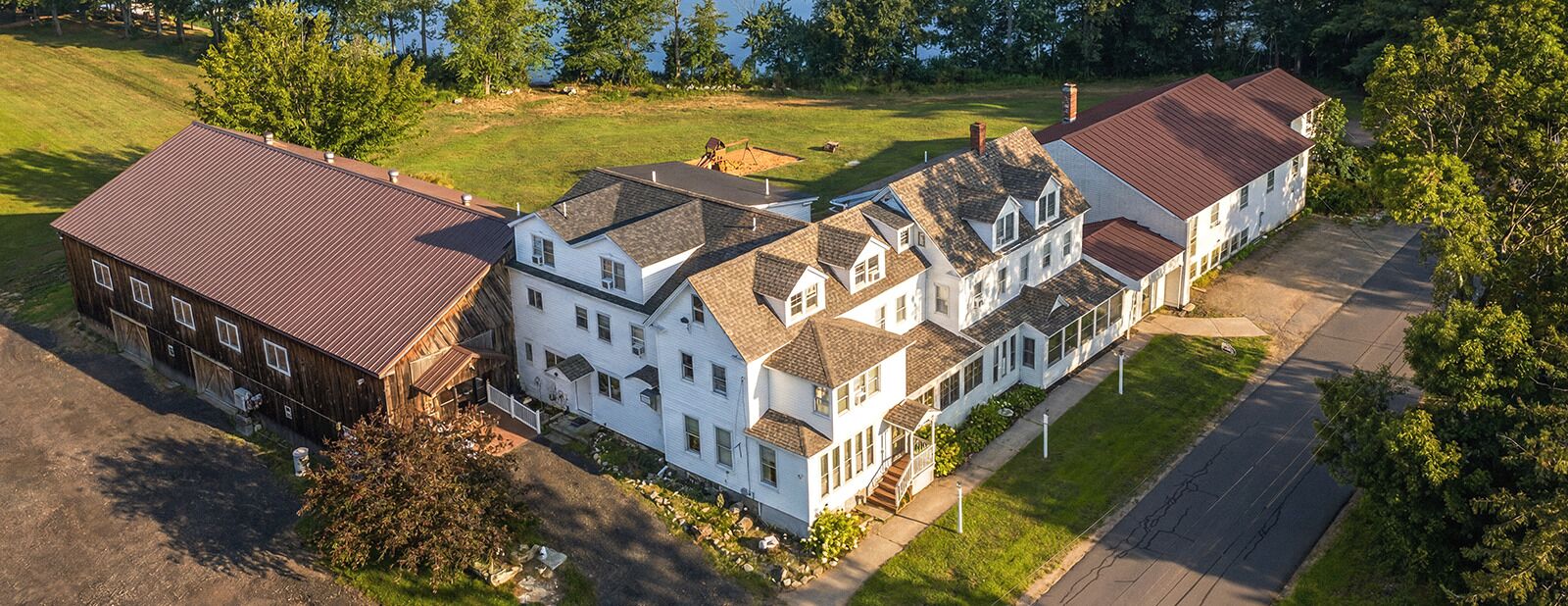 A large, multi-story residential building with a central courtyard, surrounded by a well-maintained lawn and trees.