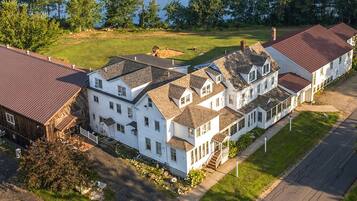 A large, multi-story residential building with a central courtyard, surrounded by a well-maintained lawn and trees.