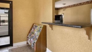 A reception area with a counter, a coffee machine, and a bulletin board. - Best Way Inn & Suites (New Orleans)