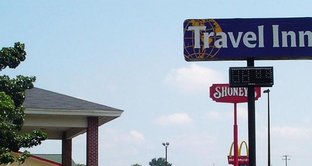 A Travel Inn sign, a McDonald's logo, and a Shoney's logo.