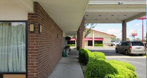 A building with a brick facade, a covered walkway, and a McDonald's sign in the background.
