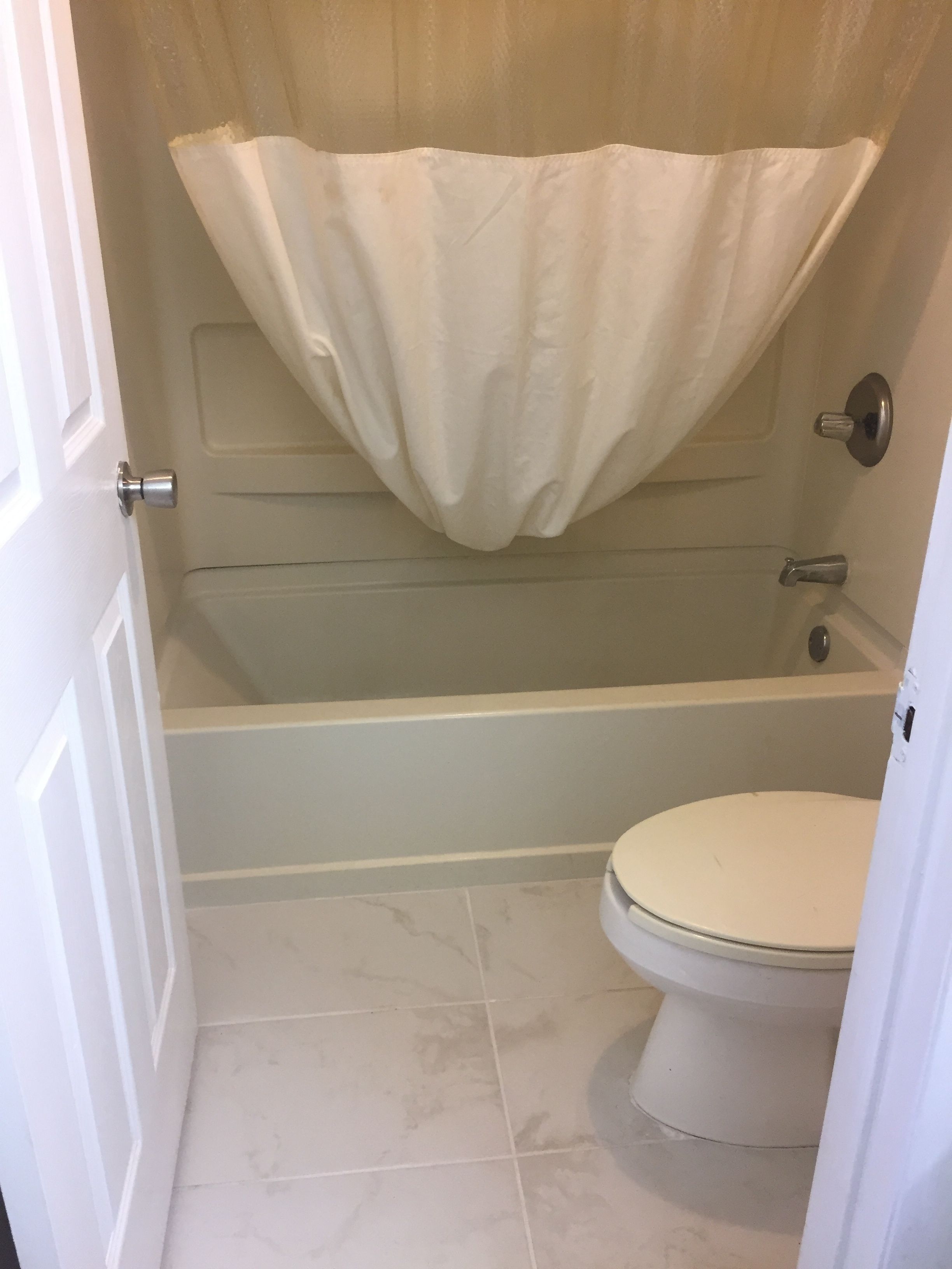 Une salle de bain avec une baignoire, des toilettes et un rideau de douche.