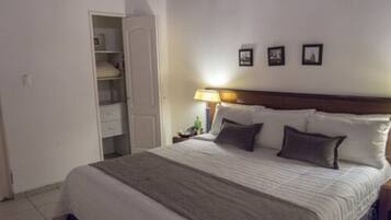 A hotel room with a bed, a nightstand, a lamp, and a wardrobe.