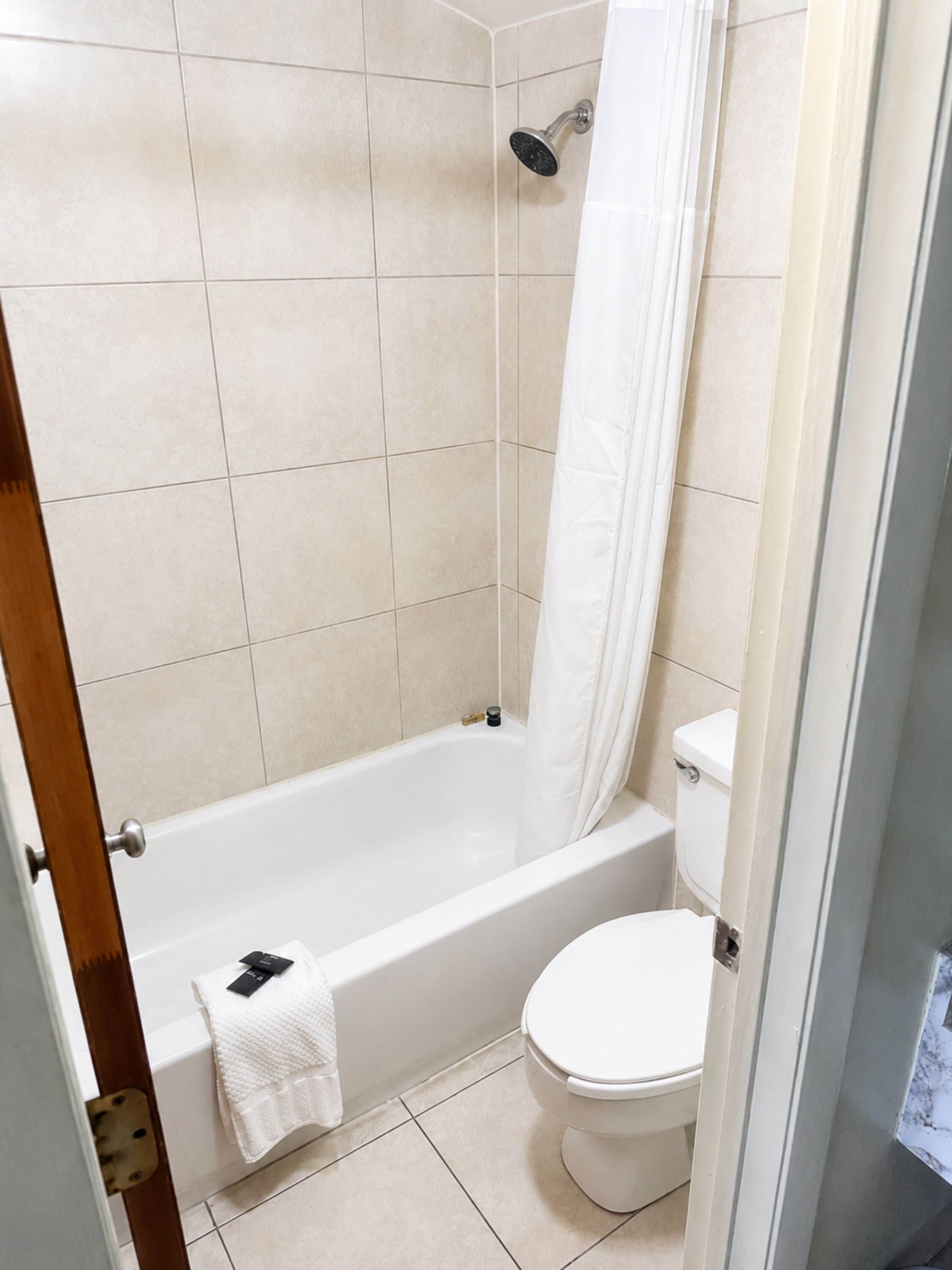 A bathroom with a bathtub, toilet, and shower curtain.