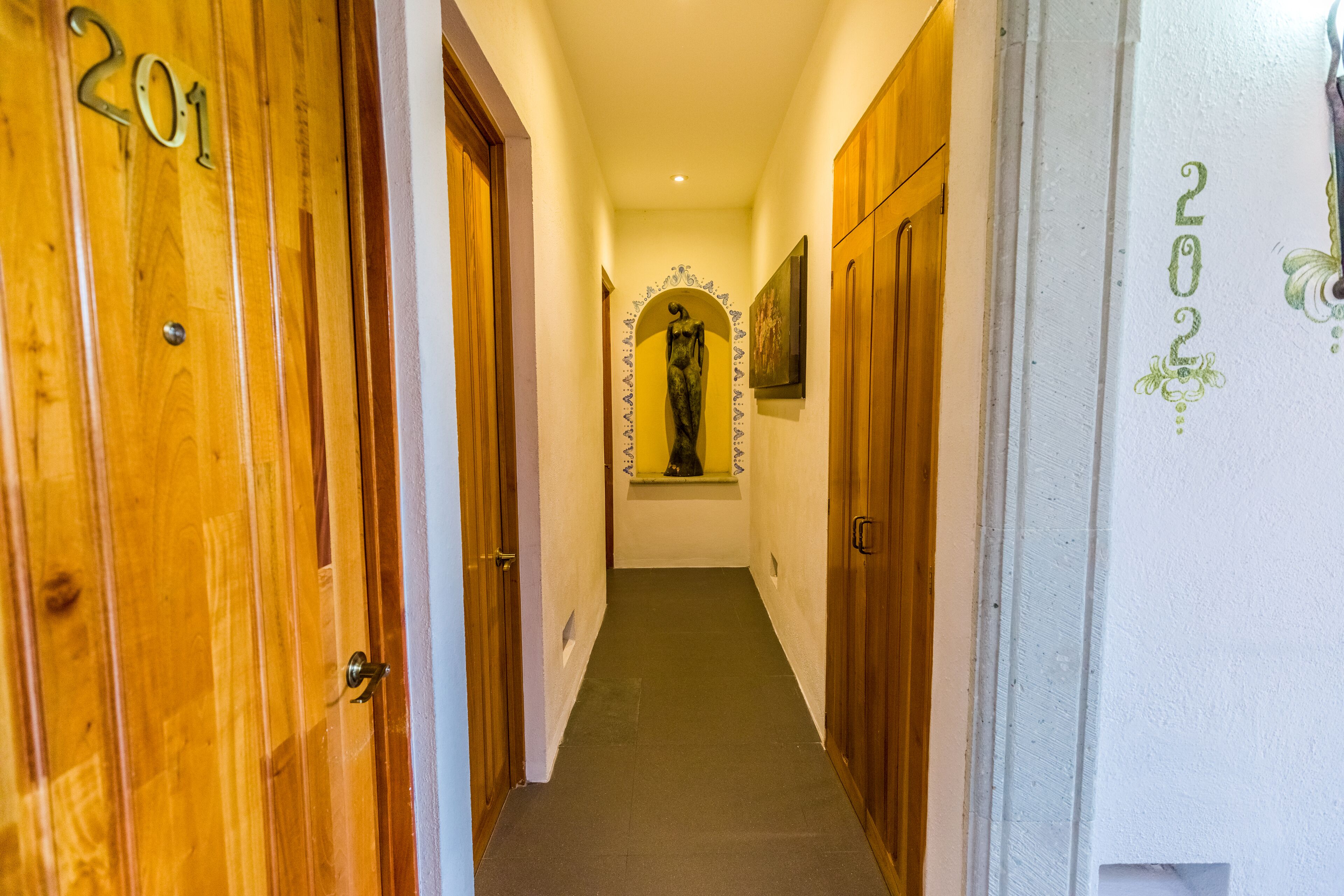 A hallway with wooden doors numbered 201 and 202, leading to rooms.