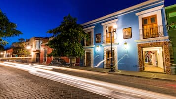 Un edificio histórico con fachada azul, un balcón con barandilla de hierro forjado y un letrero que dice “FIA NAL”.