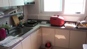 A kitchen with a sink, stove, and various kitchen items. - OxbloodK (Gwangju)