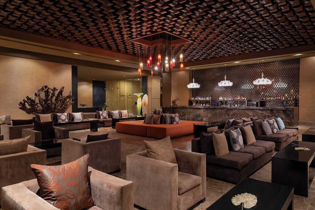 Un vestíbulo moderno con sofás, sillones y una zona de bar.