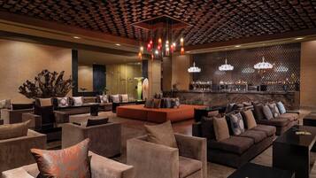 Un vestíbulo moderno con sofás, sillones y una zona de bar.