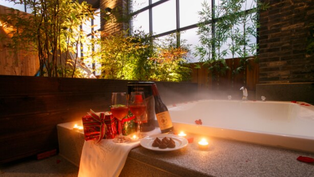A spa area with a bathtub, candles, and a bottle of wine on a table. - The Classic by Hotelone (Wanju)