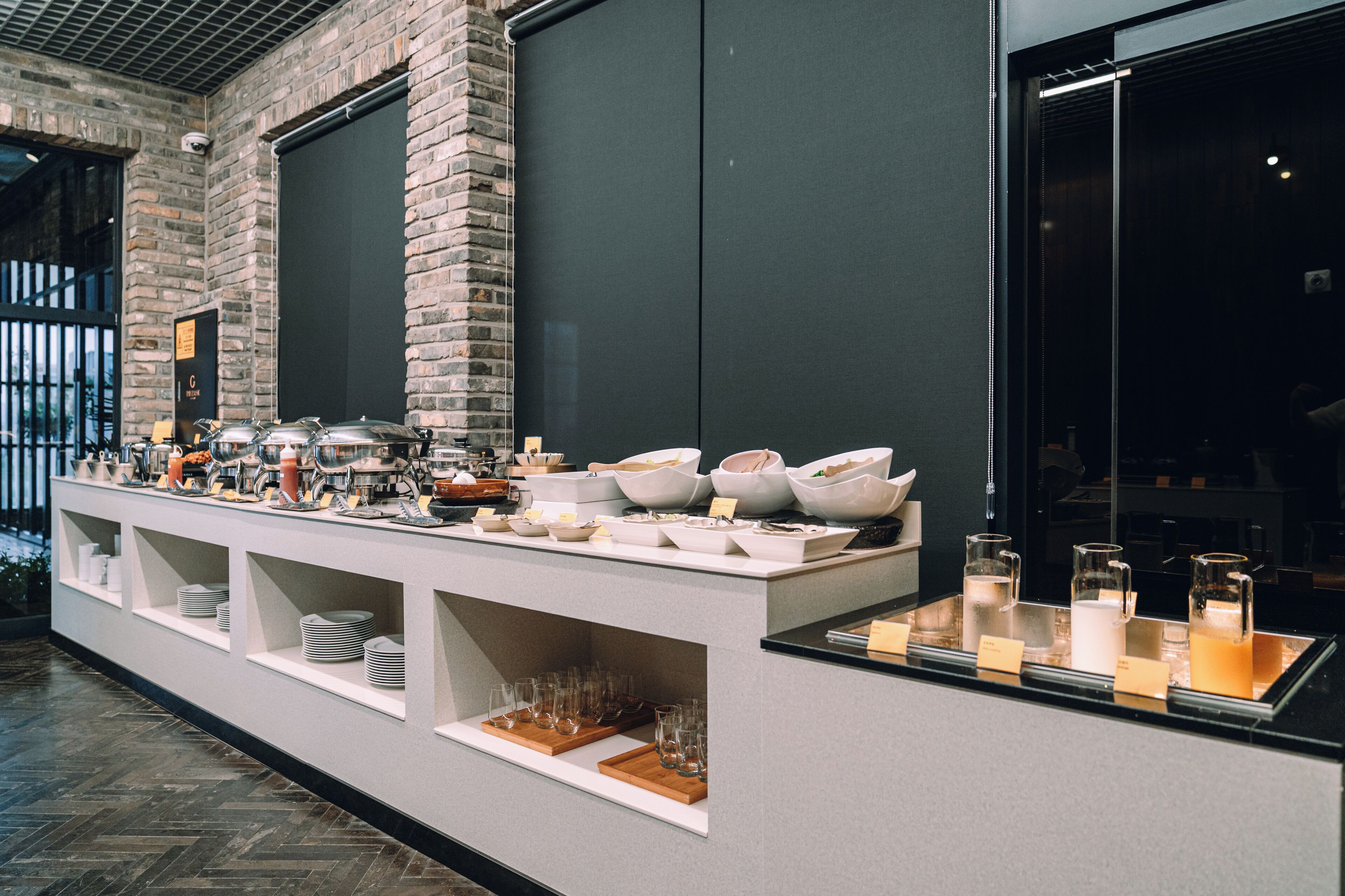 Un buffet proposant une variété de plats et de boissons, avec de la vaisselle en verre.
