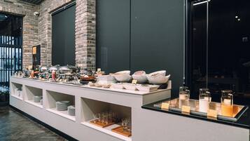 Un buffet proposant une variété de plats et de boissons, avec de la vaisselle en verre.
