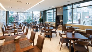 A modern dining area with multiple tables and chairs, large windows offering city views, and a clean, well-lit interior. - Sotetsu Hotels The Splaisir Seoul Dongdaemun (Seoul)