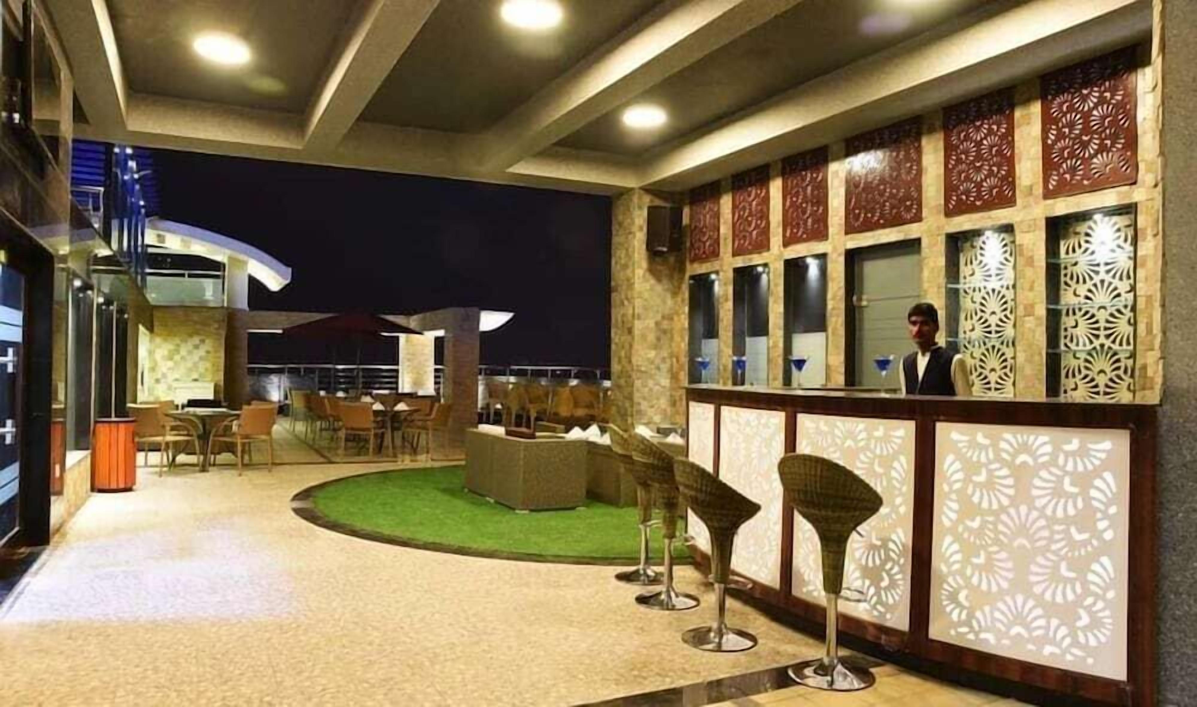 An outdoor seating area with tables and chairs, a pool, and decorative panels.