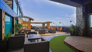 An outdoor patio area with seating and a view of the city skyline. - Renest Jaipur (Jaipur)