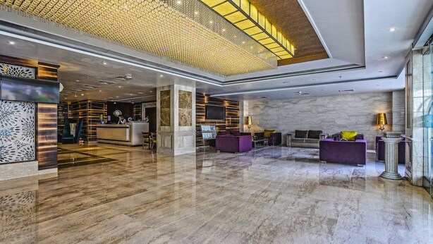 A spacious lobby with a marble floor, a reception desk, and a seating area with purple sofas. - Renest Jaipur (Jaipur)