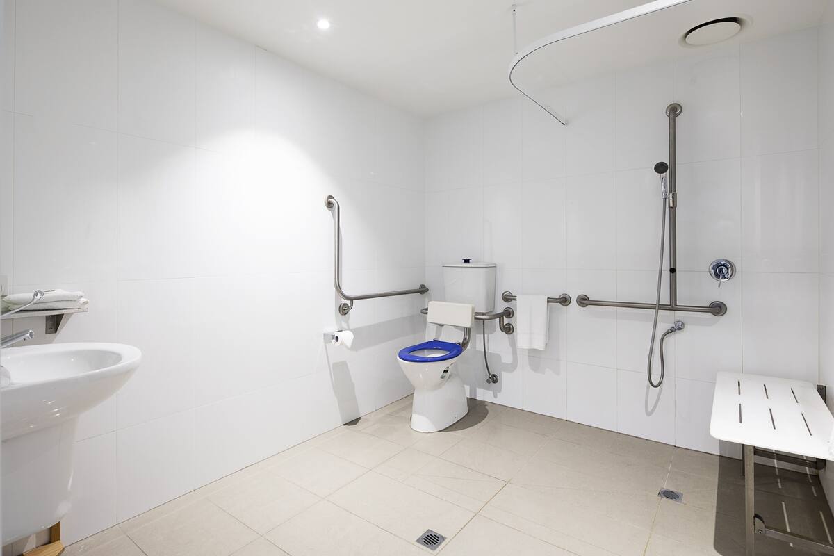 Ein modernes Badezimmer mit Toilette, Waschbecken und Duschbereich.