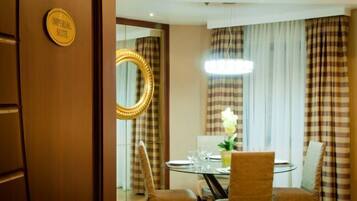 A dining area with a round table, chairs, and a chandelier.