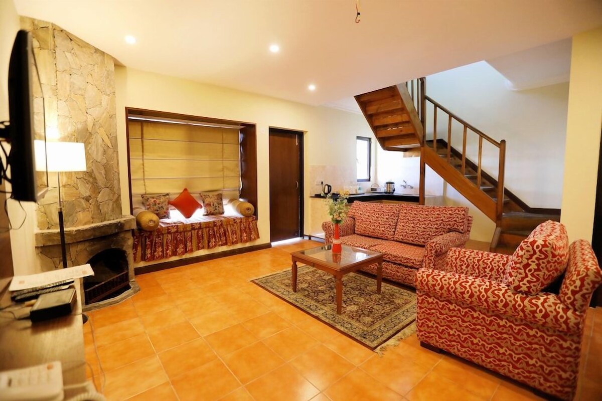 A living room with a fireplace, a sofa, a coffee table, and a staircase.