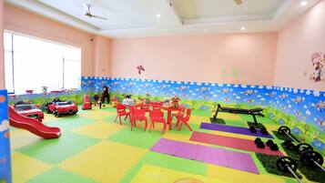 Children can play on a slide, ride toy cars, and engage in various activities at this playroom.