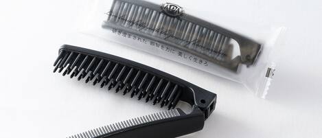Un pettine nero e un astuccio per pettine con testo in giapponese.