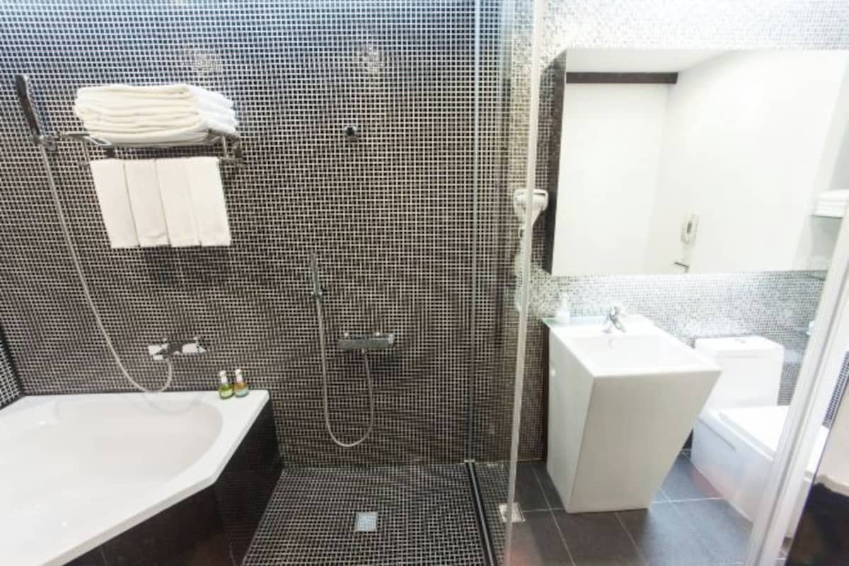 Un baño moderno con ducha, lavabo e inodoro.