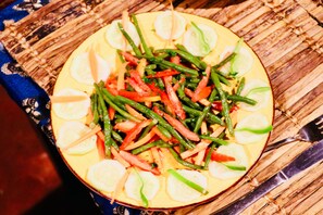 Un plato de vegetales cortados, incluyendo pepinos, judías verdes y tomates.