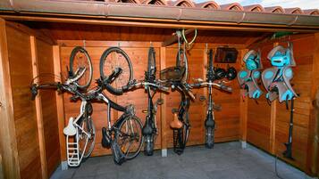 Una habitación de madera con piso de baldosas, varias bicicletas y cascos.