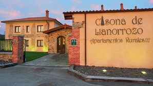 Un complejo de apartamentos rurales con fachada de piedra y tejado de tejas.